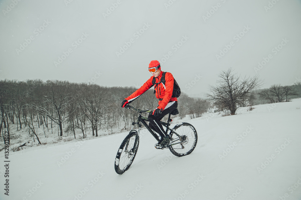 Extreme cyclist rides in the winter snowy forest Extreme cyclist rides in the winter snowy forest