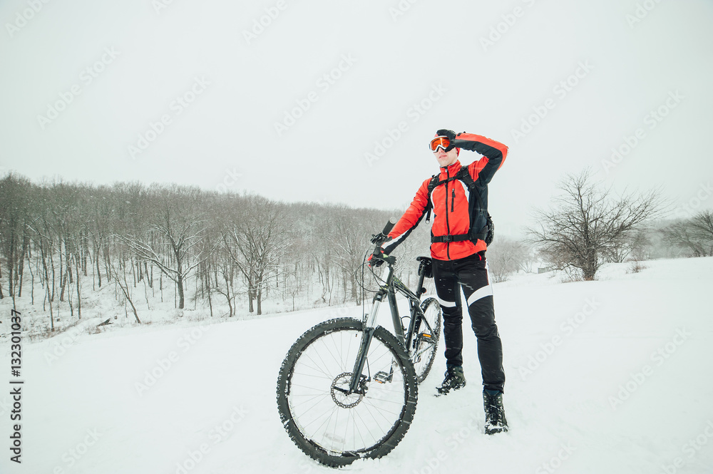Extreme cyclist rides in the winter snowy forest Extreme cyclist rides in the winter snowy forest