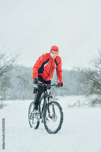 Extreme cyclist rides in the winter snowy forest