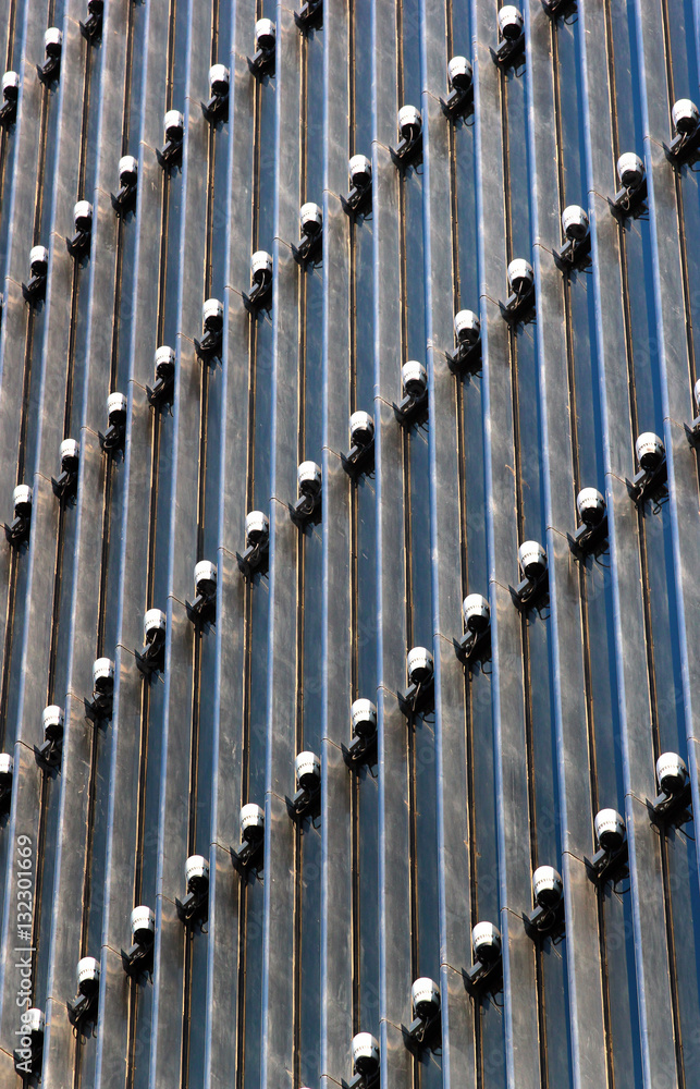 Obraz premium Lighting equipment on facade of modern office building. Lamps illuminate the exterior at night.