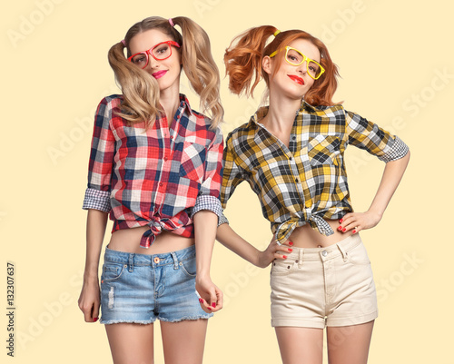 Fashion woman Jump, Having Fun Crazy Cheeky Dance. Nerd in fashion Trendy Plaid Shirt. Hipster Sisters Best Friends Smile. Twins in Stylish Summer Outfit. Model Hipster Girl jumping,Fashion Sunglasses