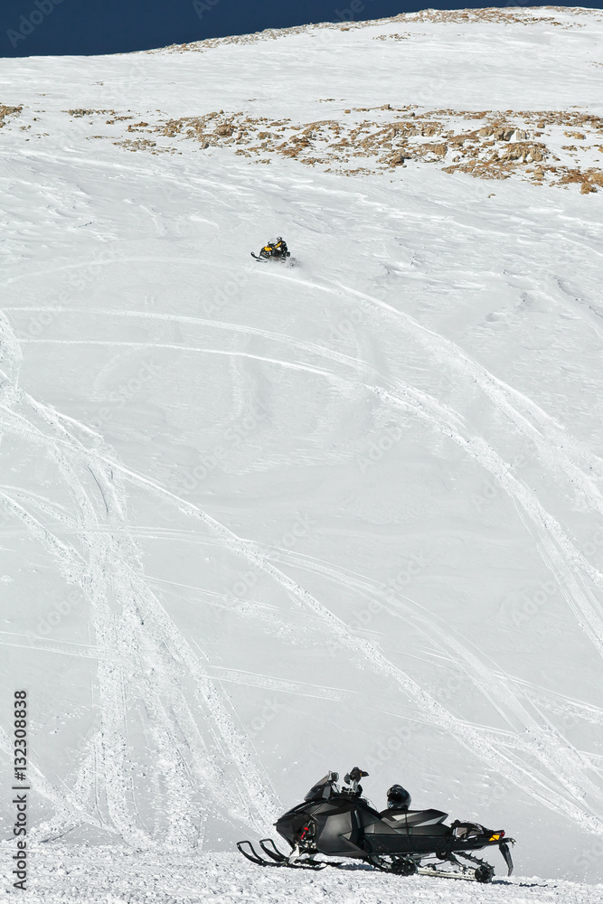 Standing snowmobile and sled in motion. State Nature Reserve in Adygea, Russia.