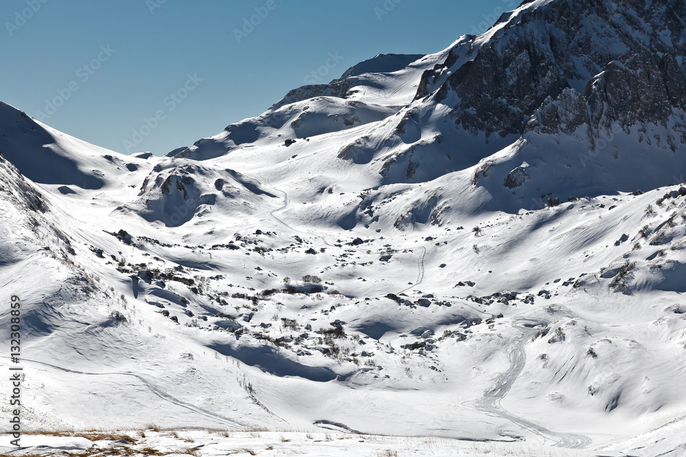 Traces of the snowmobile on a snow-covered mountainside in the National Nature Reserve in Adygea, Russia.