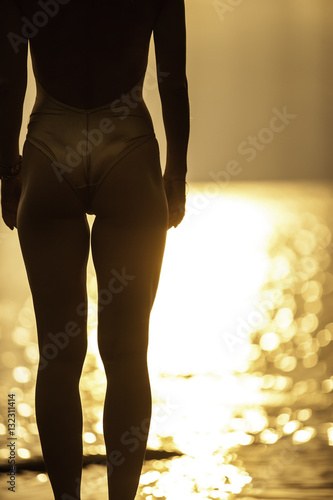 woman in golden swimsuit standing on the beach