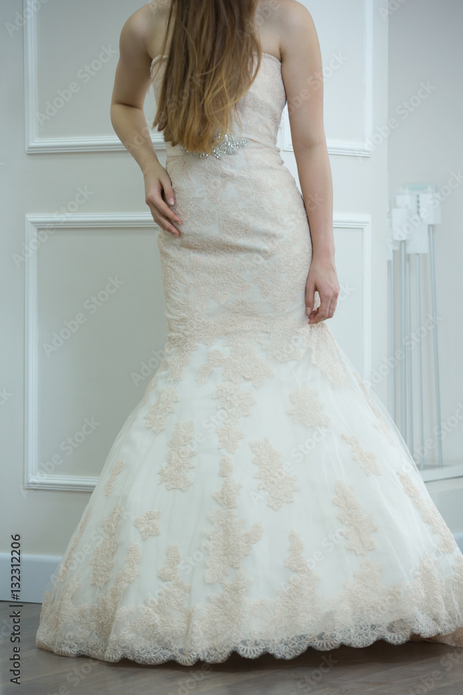 Bride white wedding dress on model in showroom, vertical Bride white wedding dress on model in showroom, vertical