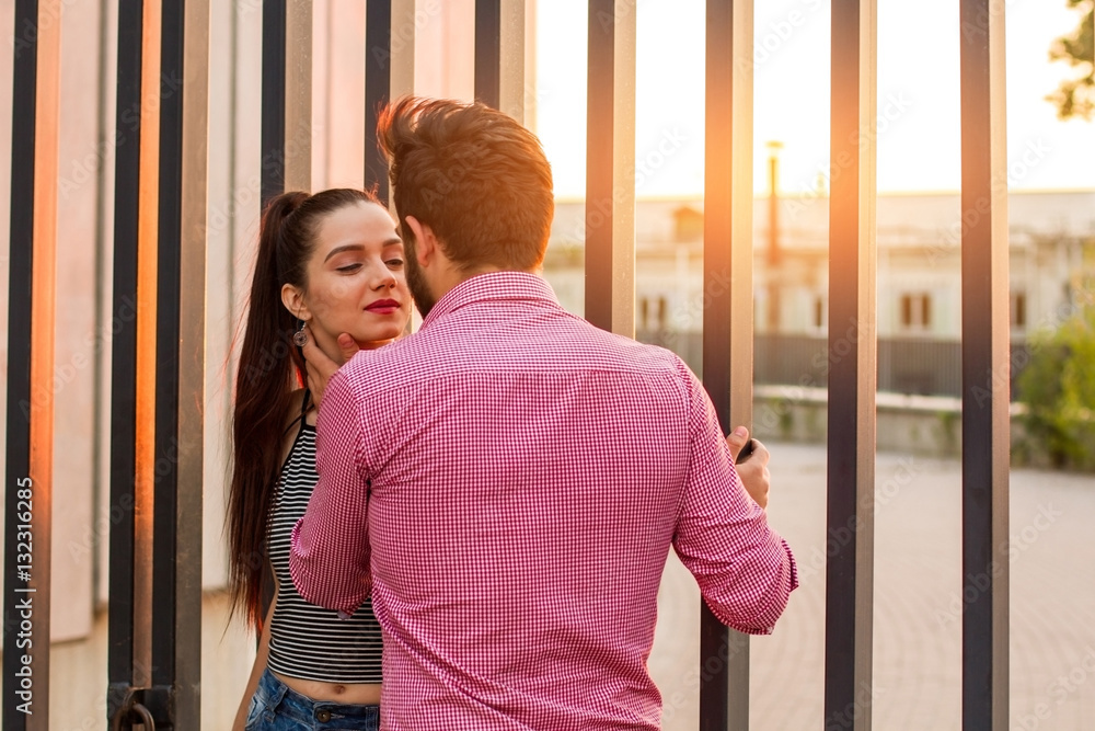 Romantic couple and sunlight. Man touching woman's neck. Tender and careful.