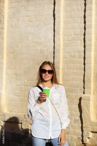 Young woman with cup coffee in sunglasses