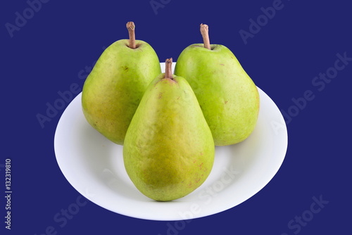 Pears on white plate on blue background
