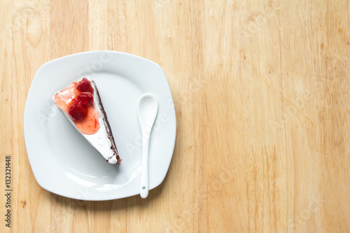 Strawberry cake with white plate on wooden background