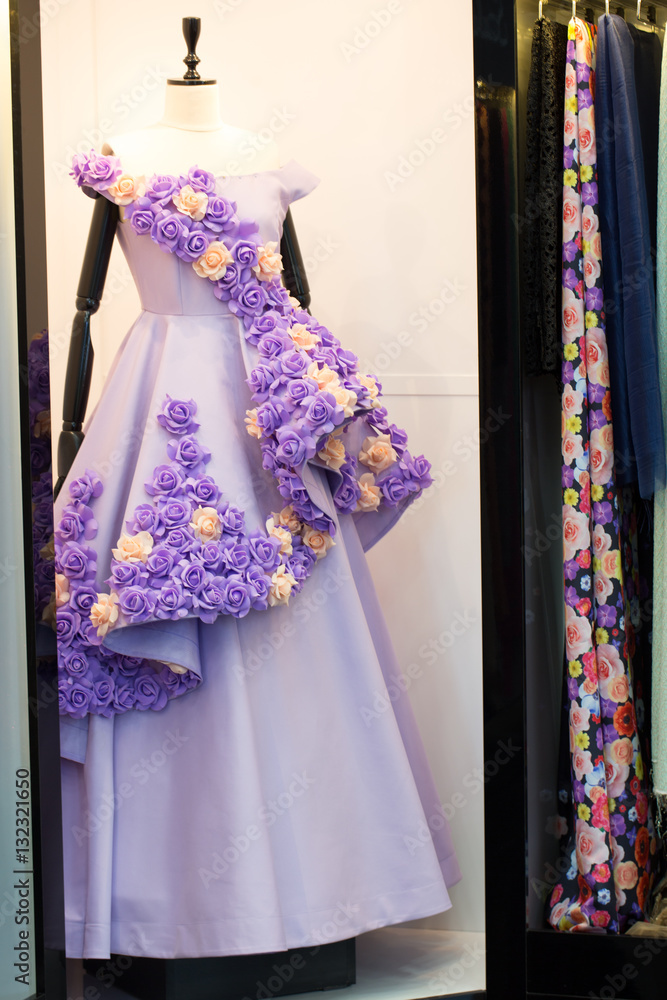Violet long evening dress in the showroom with details of flowers, vertical 