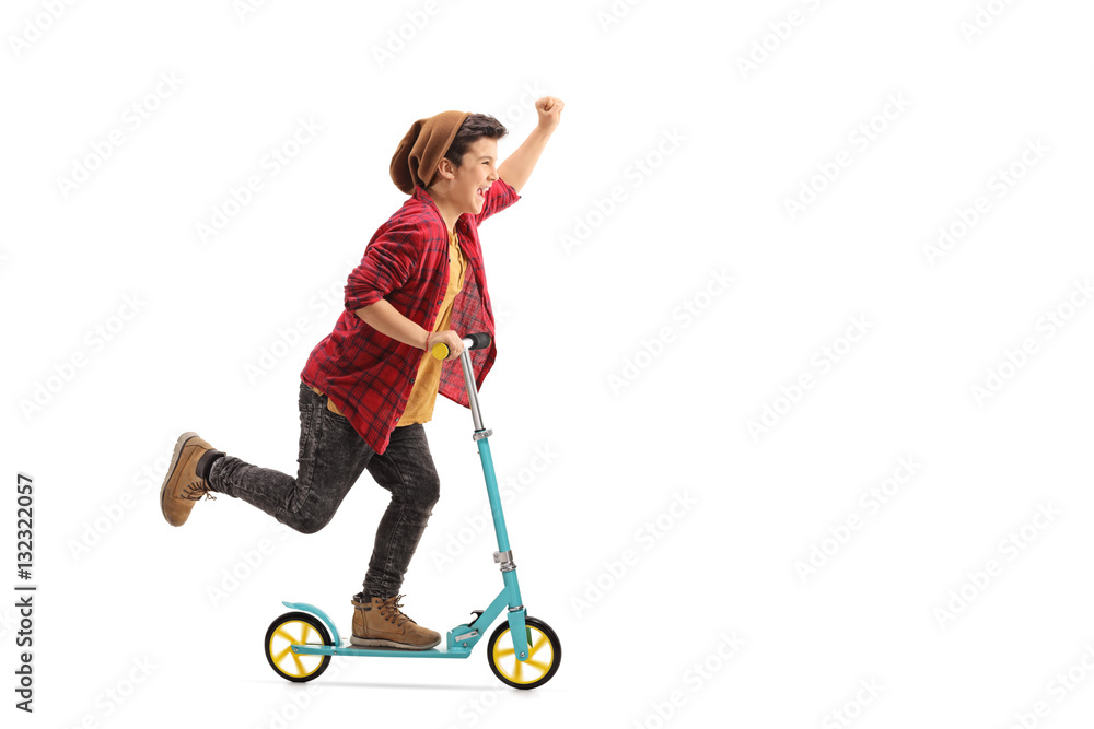 Excited little boy riding a scooter and gesturing with his hand Excited little boy riding a scooter and gesturing with his hand