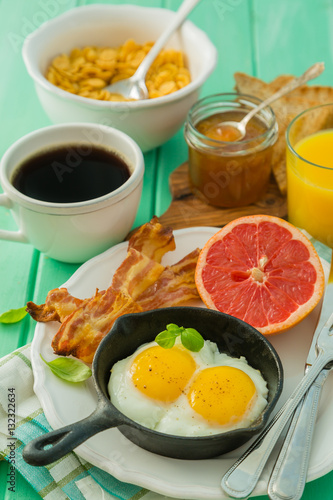 Summer breakfast - eggs, bacon, toast, jam, coffee, juice