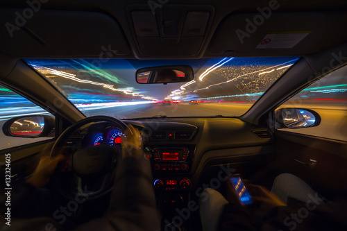 Night road view from inside car natural light street and other cars is motion blurred. © pozdeevvs