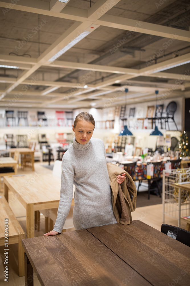 Pretty, young woman choosing the right furniture Pretty, young woman choosing the right furniture
