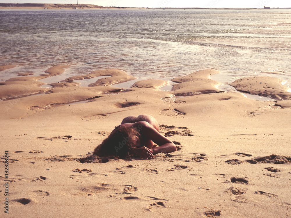 Nude female lying on the on the beach in Portugal Stock Photo | Adobe Stock