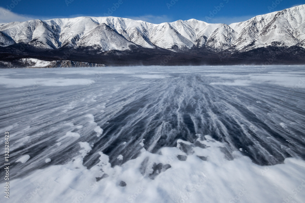 Snowstorm, strong ground wind from the mountains carries snow through ice field Snowstorm, strong ground wind from the mountains carries snow through ice field