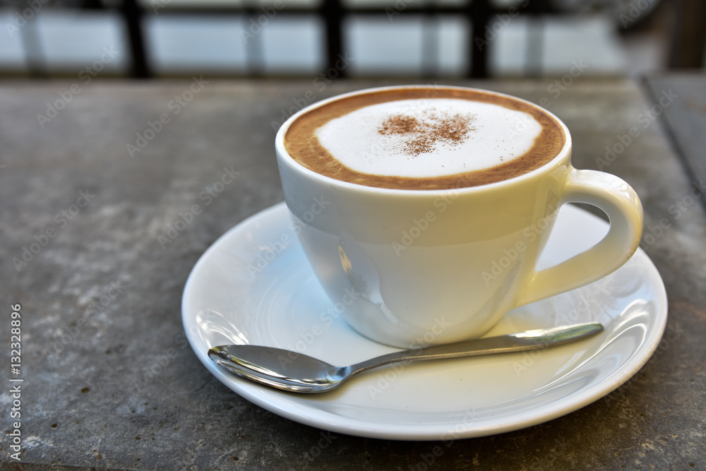 Obraz premium hot coffee cup on rock table on brown background