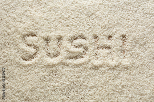 Surface made of rice with "sushi" written in the center.