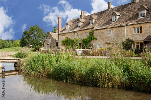 Row of stone cottages on Malthouse Lane next to the River Eyre, Lower Slaughter, England