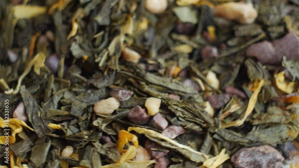 Green tea flavored with chocolate and almond pieces, close up. Loopable rotation. In front of the camera rotates plate with green tea. Green tea flavored with chocolate and almond pieces, close up. Loopable rotation. In front of the camera rotates plate with green tea.