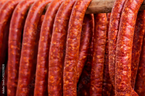 Row of Smoked Sausages hanging out to dry on a wooden pole