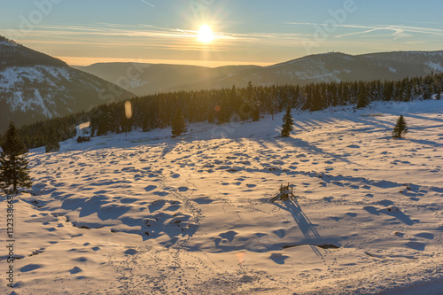 Beautiful winter sunrise with lens flare in Giant mountains, Czech Republic
