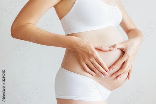 Pregnant woman in white underwear. Young woman expecting a baby