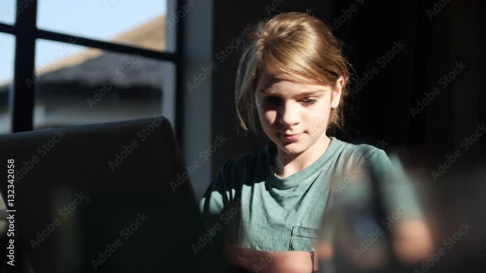slow motion shot and tracking camera of a girl doing homework behind her laptop slow motion shot and tracking camera of a girl doing homework behind her laptop