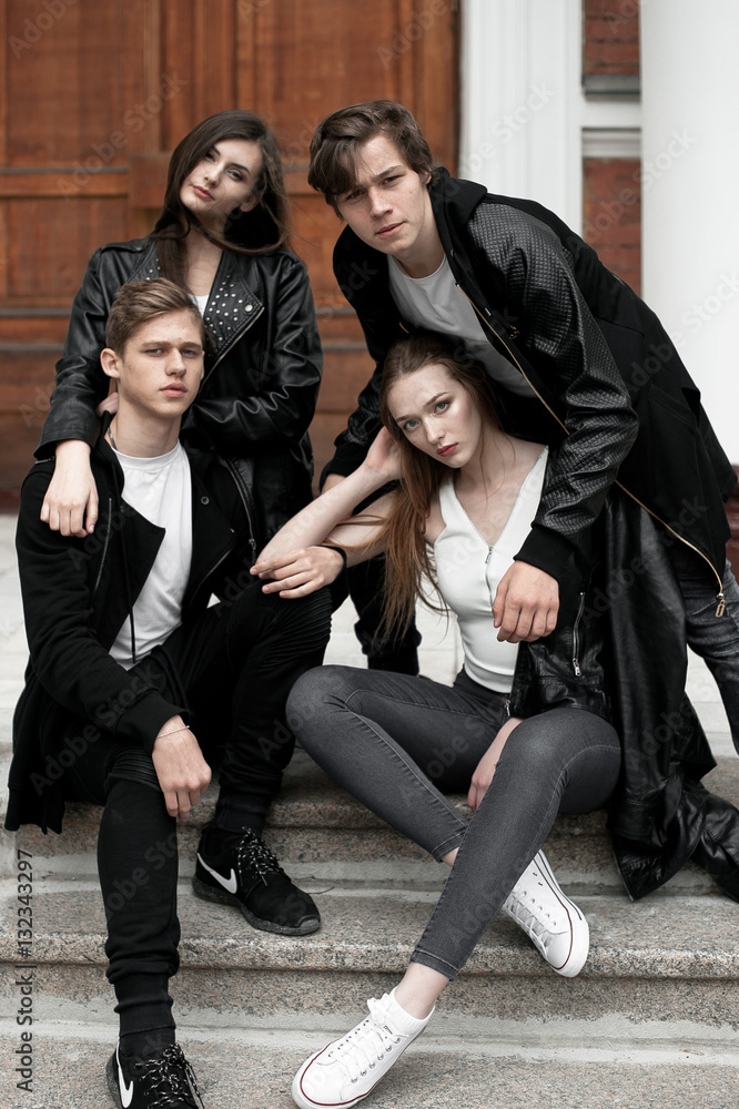 Young elegant trendy friends outdoors, wearing black and white clothing