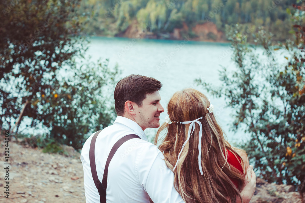 Fototapeta premium couple sitting by the lake on a bench