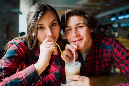 Group of young friends hanging out at a coffee shop. Young men and women meeting in a cafe having fun and drinking coffee. Lifestyle  friendship and urban life concepts.