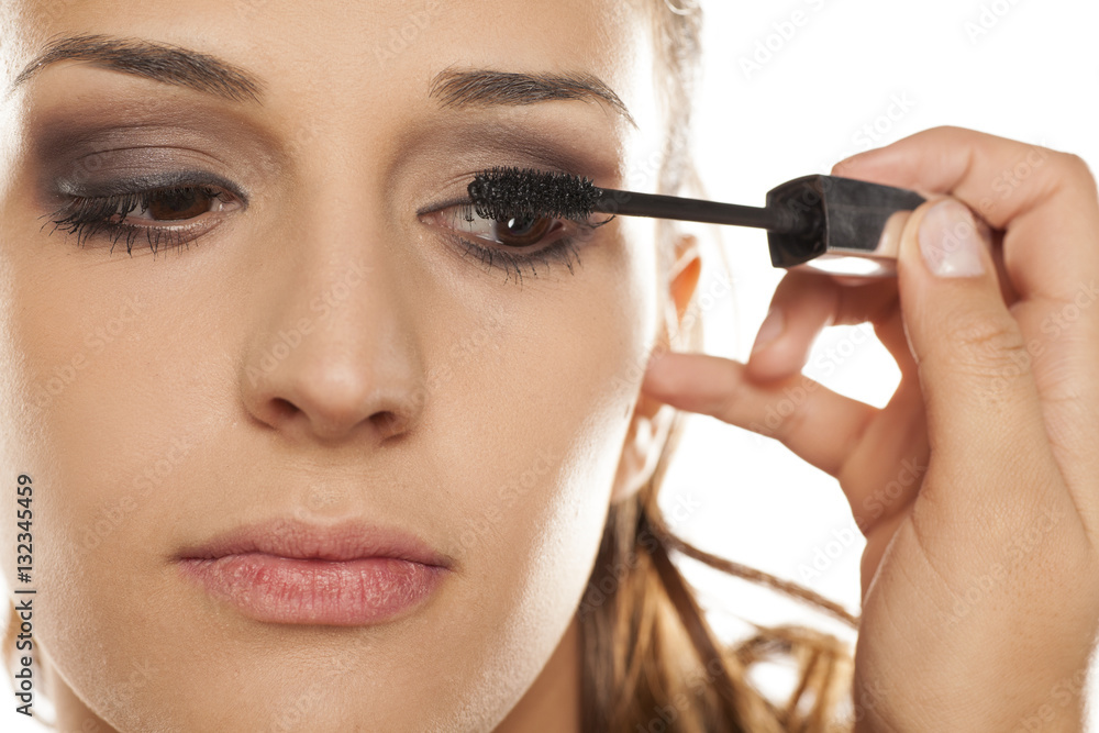 young woman applied mascara to her lashes