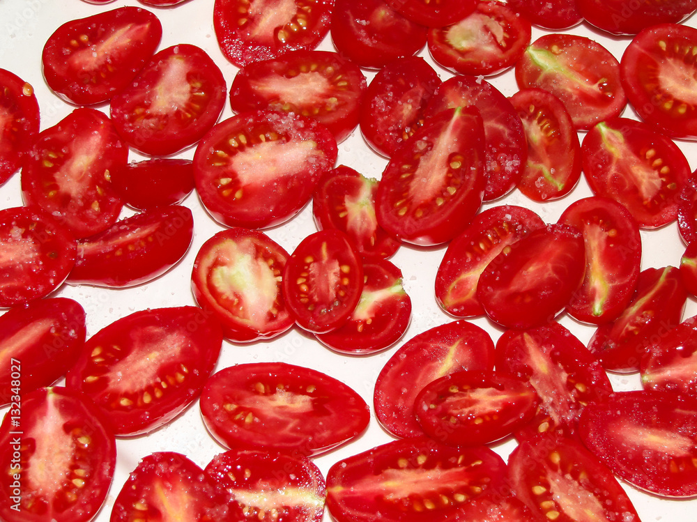 Sliced tomatoes sprinkled with salt on a white plate Sliced tomatoes sprinkled with salt on a white plate