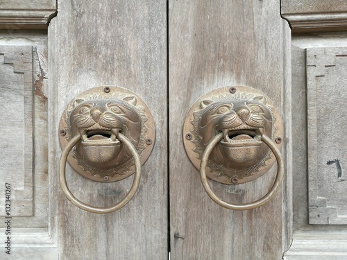 Chinese style door knob with lion head knocker at a Buddhism pagoda in Asia