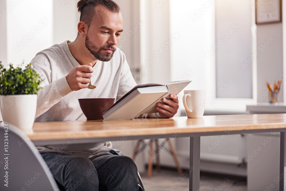Focused handicapped man having breakfast Focused handicapped man having breakfast