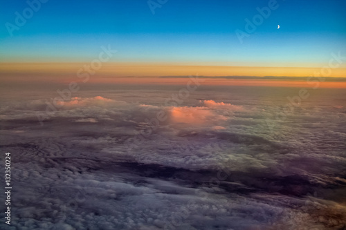 Aerial view of a cloudy sunset while flying above the clouds © Mulderphoto