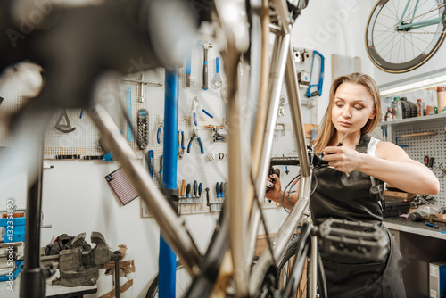 Bilde på lerret Mindful mechanic renovating the bicycle in the repair shop
