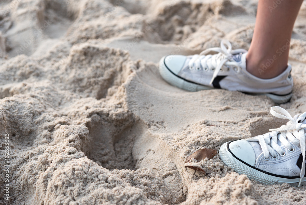 Naklejka premium shoes on tropical sand beach