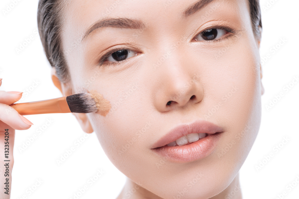 Pretty good looking woman using a cosmetic brush Pretty good looking woman using a cosmetic brush