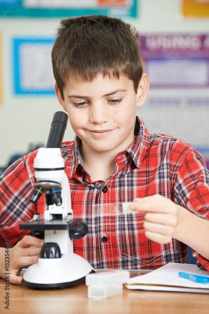 Male Pupil Using Microscope In Science Lesson Male Pupil Using Microscope In Science Lesson