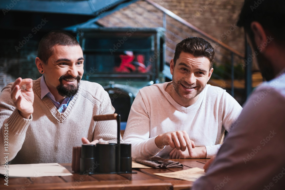 Cheerful happy men discussing something Cheerful happy men discussing something