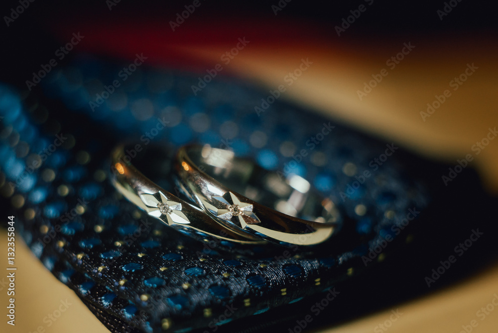 two wedding rings on a blue tie two wedding rings on a blue tie