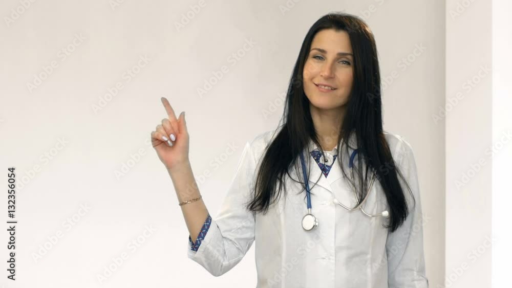 Medical smiling doctor woman with stethoscope point finger up to corner Medical smiling doctor woman with stethoscope point finger up to corner
