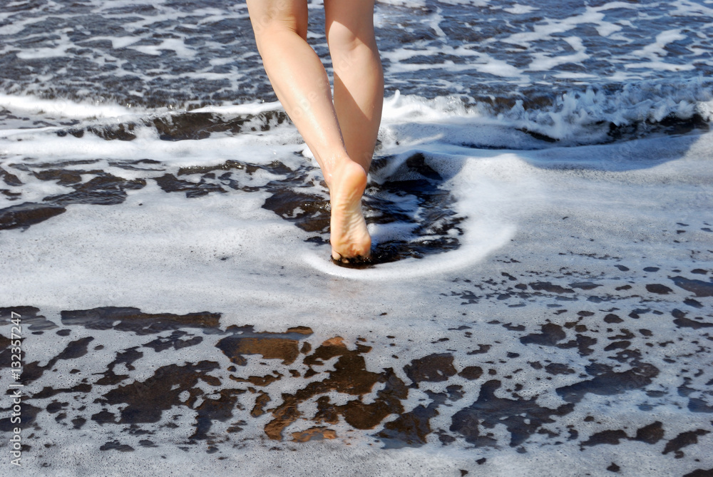 Beautiful female legs and black sand beaches Beautiful female legs and black sand beaches