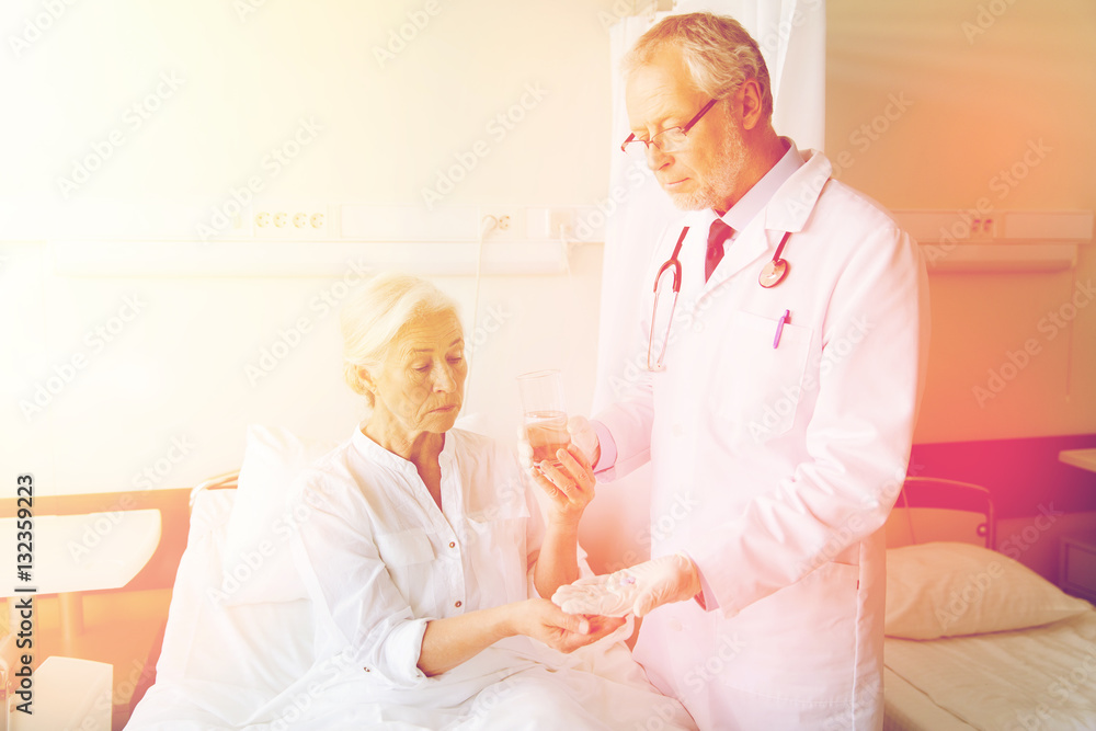 doctor giving medicine to senior woman at hospital