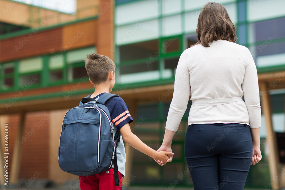 elementary student boy with mother at school yard elementary student boy with mother at school yard