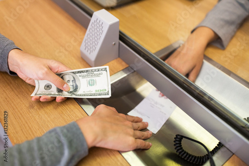 customer with money taking receipt from bank clerk