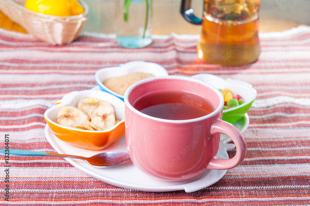 Cup of hot tea with snacks on a tray on the served table. Relax breakfast concept. Selective focus Cup of hot tea with snacks on a tray on the served table. Relax breakfast concept. Selective focus
