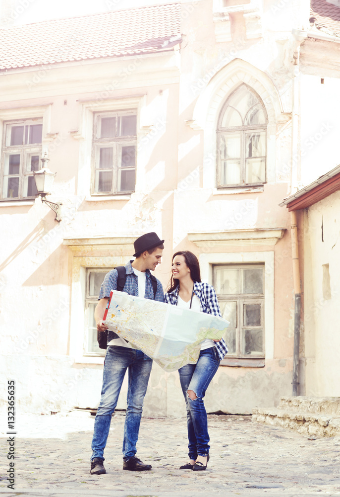 Couple of young travelers with a map on the street Couple of young travelers with a map on the street