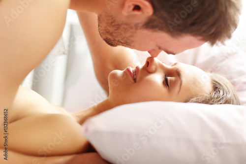 Young couple kissing in bed